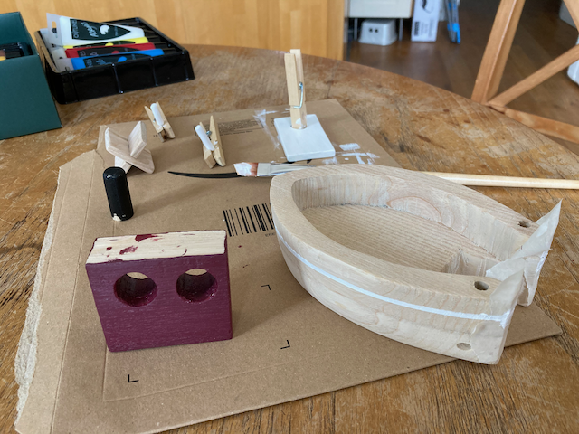 Painting the separate parts of a toy boat.